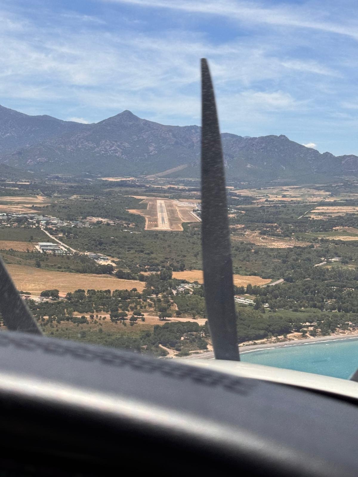 Runway ahead on approach over a Mediterranean coastline